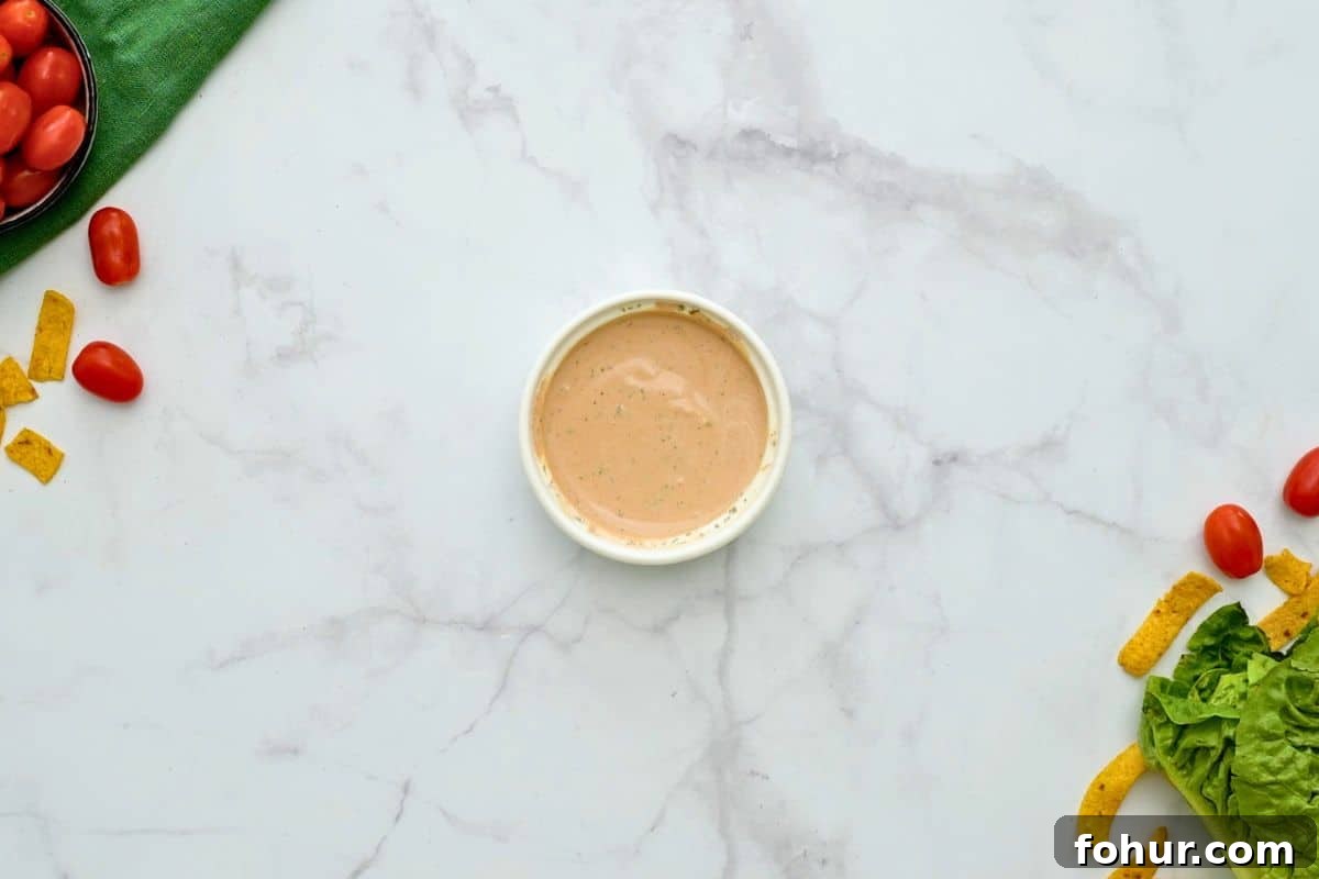 Sweet barbecue sauce mixed with creamy ranch dressing in small bowl for dressing for BBQ Chicken salad.