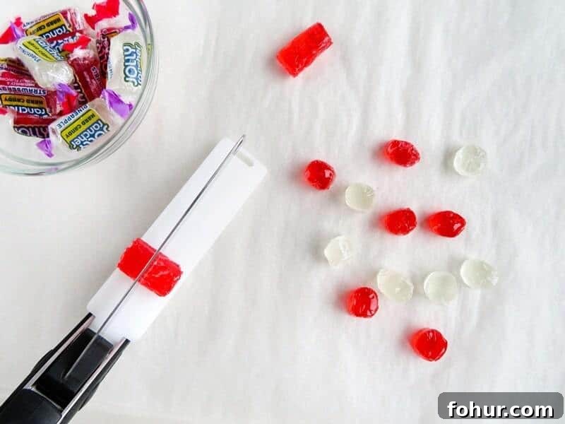 Kitchen scissor cutting jolly ranchers in half.