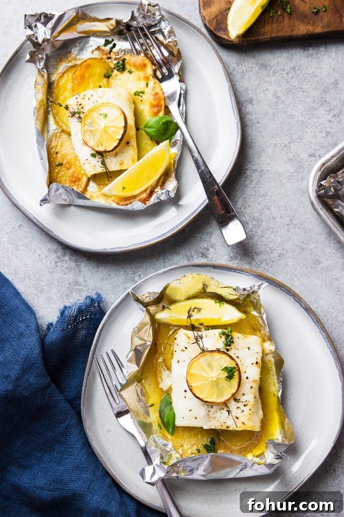 Lemon Herb Fish Baked in Foil with Potatoes 2 two fish in foil packets with potatoes on a plate