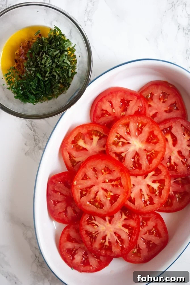 Marinated Italian Tomato Salad with Basil 3 a plate of sliced beefsteak tomatoes next to a bowl of herb marinade