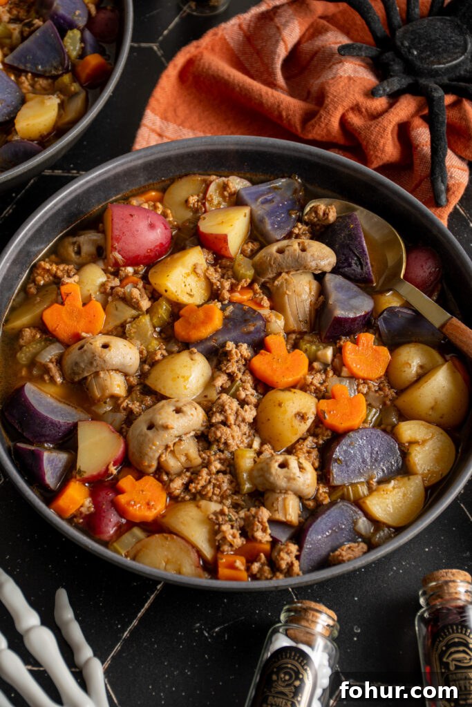 Witches' Brew Stew: Halloween Soup Recipe 2 Black bowls filled with Halloween soup showing pumpkin-shaped carrots, skull-shaped mushrooms, purple potatoes and ground turkey.