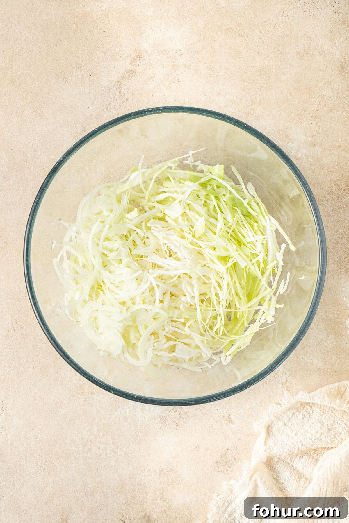 Crispy Cabbage Fritters Recipe with Tangy Yogurt Dip 3 Shredded cabbage in a glass bowl.