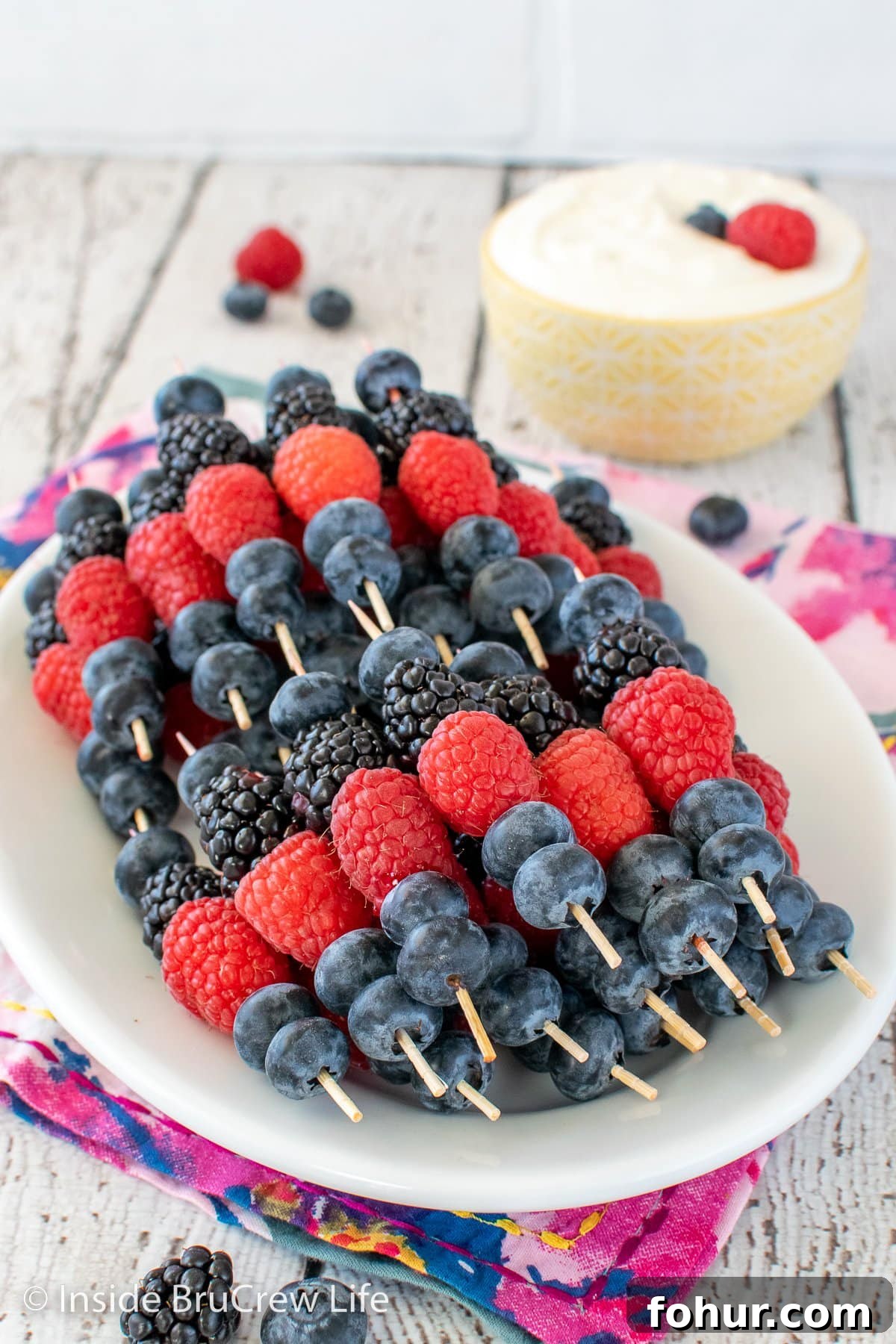 Fruit skewers on a white plate.