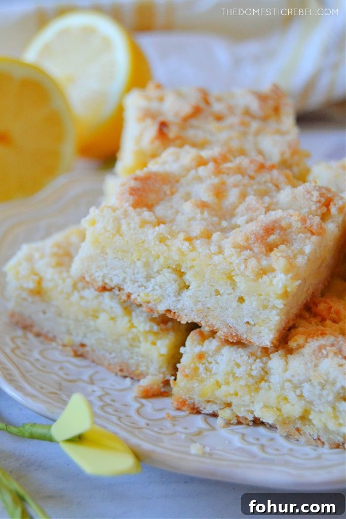a trio stack of lemon crumble bars on a white plate
