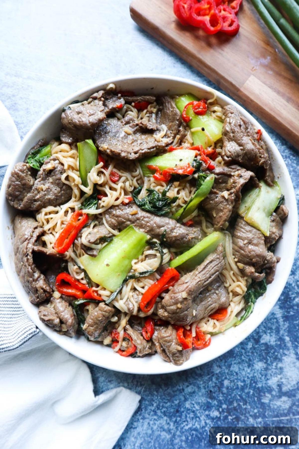 Pho Xao: Vietnamese Stir-Fried Beef and Rice Noodles 2 white plate with noodles, vegetables, and beef.
