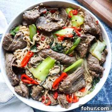 Pho Xao: Vietnamese Stir-Fried Beef and Rice Noodles 12 white plate with noodles, vegetables, and beef.