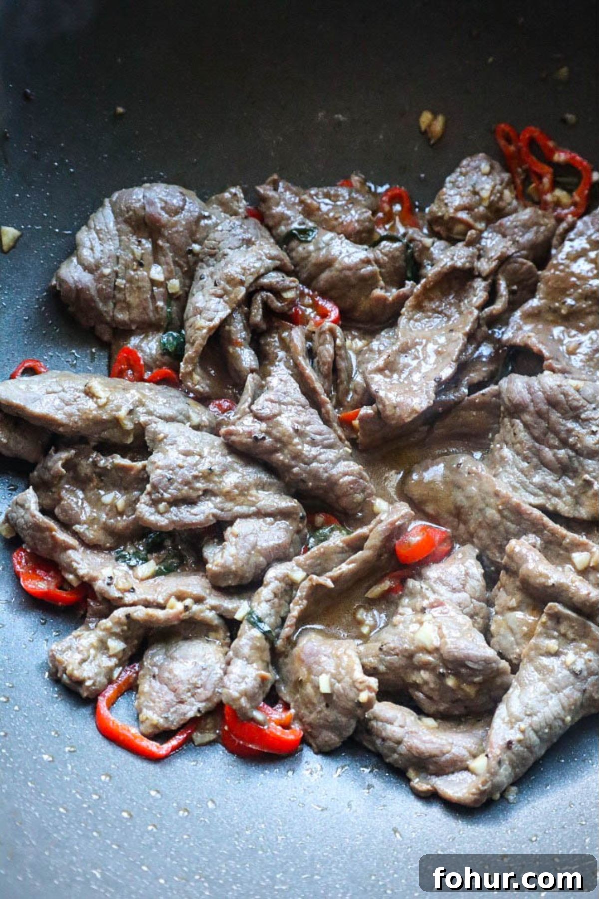 Pho Xao: Vietnamese Stir-Fried Beef and Rice Noodles 4 beef cooked with red chilis in wok.