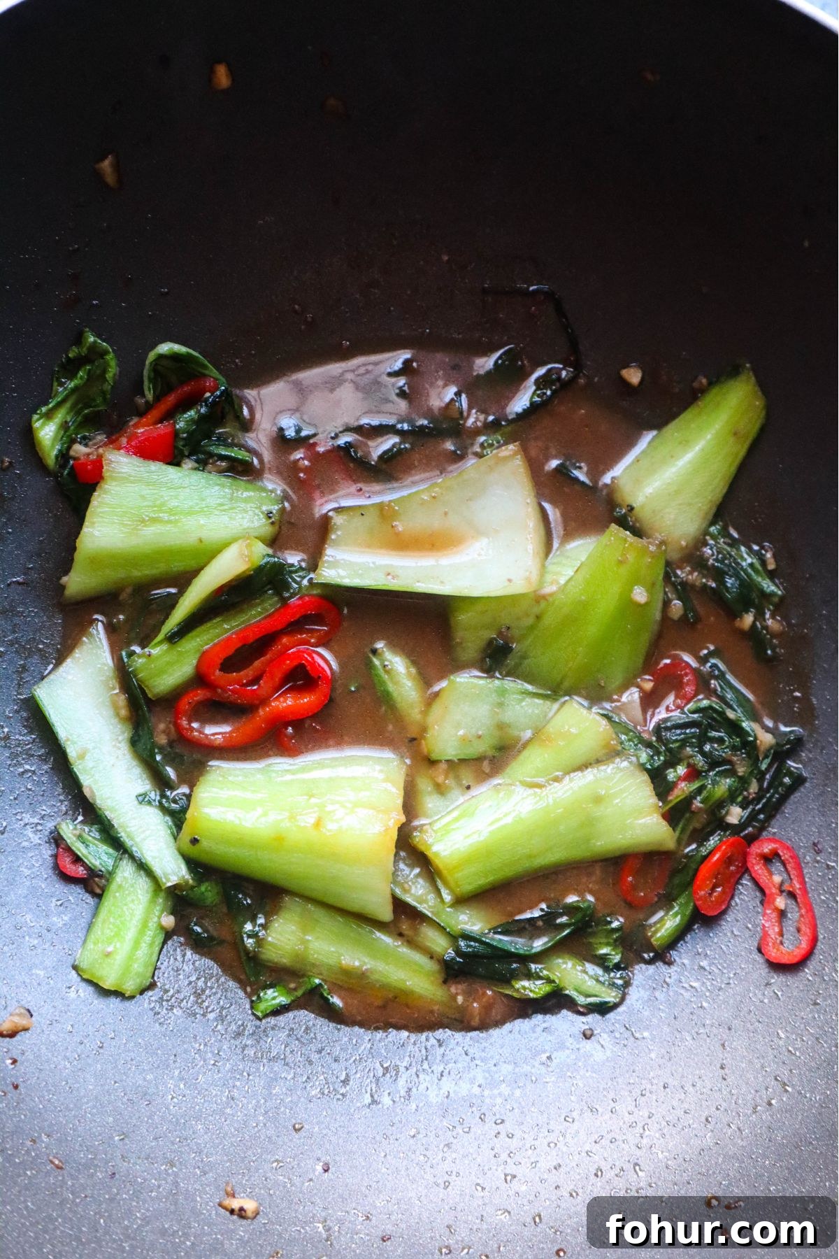 Pho Xao: Vietnamese Stir-Fried Beef and Rice Noodles 5 wok with vegetables cooked in a stir fry sauce.