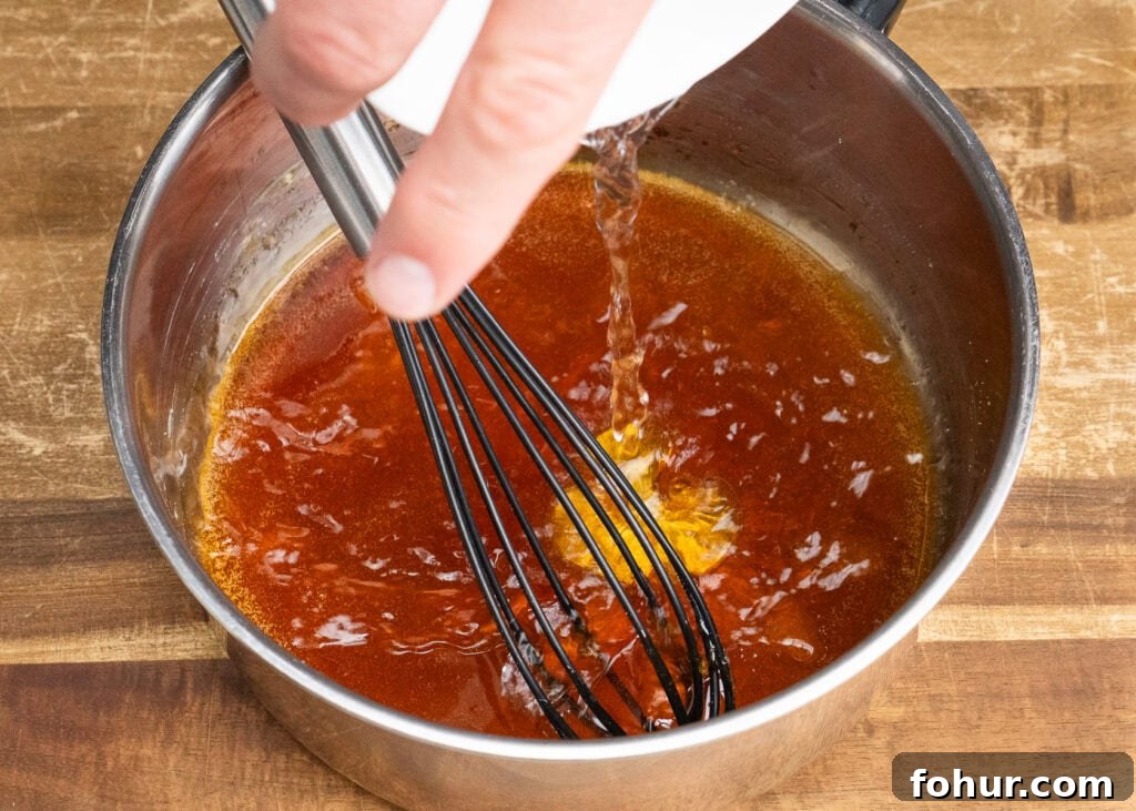 How to Make Salted Caramel Sauce 9 Pouring water into melted caster sugar to make caramel