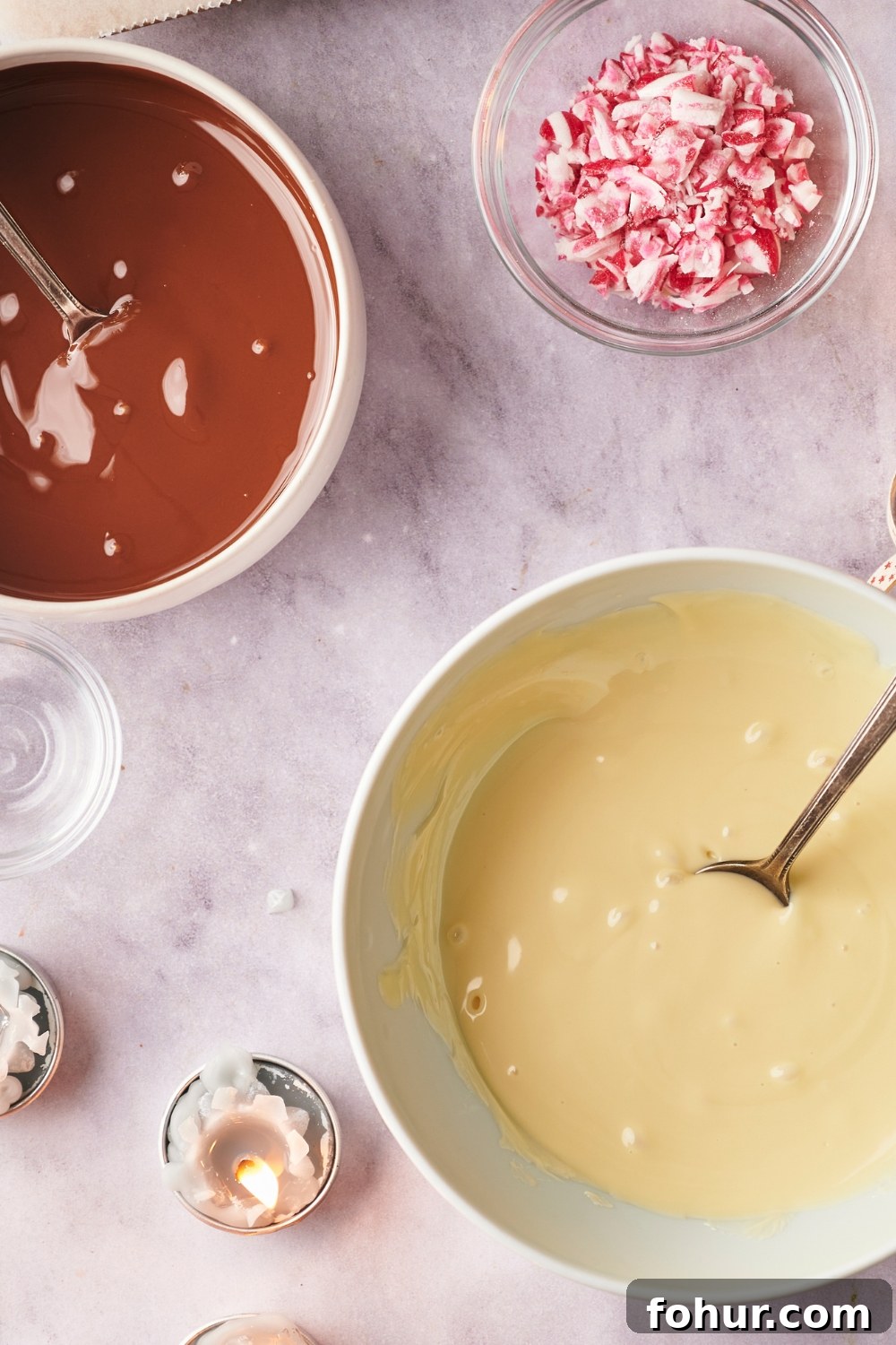 No-Bake Peppermint Bark Ready in 5 Minutes 5 A bowl of melted white chocolate and melted semisweet chocolate, a smaller bowl with crushed candy canes is next to them.