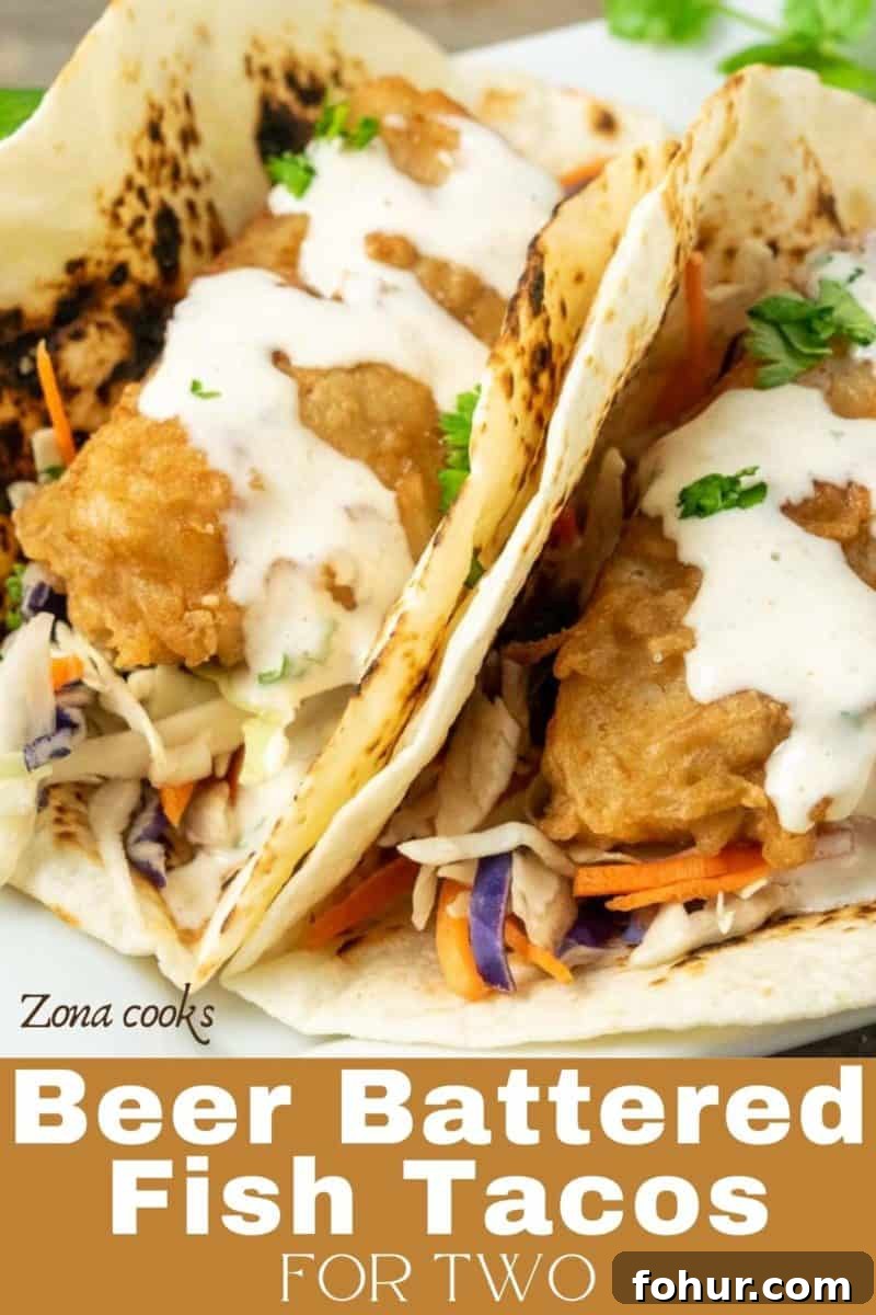 Crispy Beer-Battered Fish Tacos with Lime Slaw 10 two Baja Fish Tacos with coleslaw on a plate.