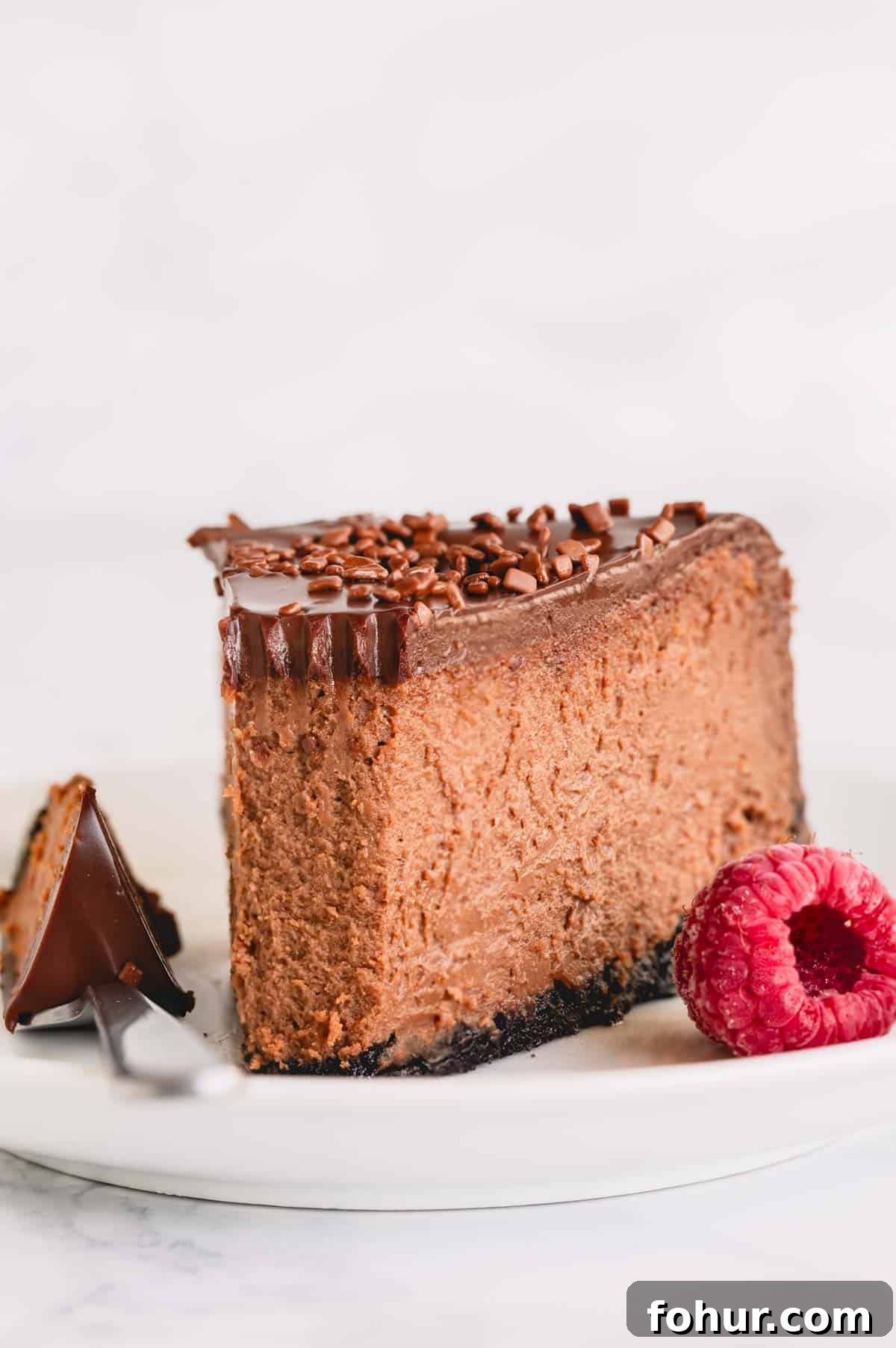Decadent Chocolate Cheesecake Recipe with Ganache 8 A slice of supreme chocolate cheesecake topped with chocolate ganache.