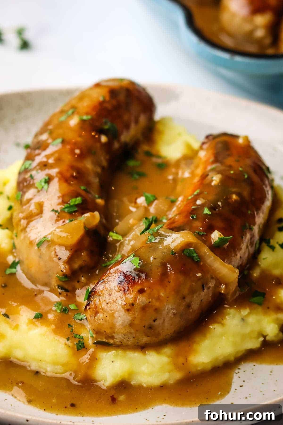 Classic British Bangers and Mash with Rich Onion Gravy 2 a plate of bangers and mash with gravy on top
