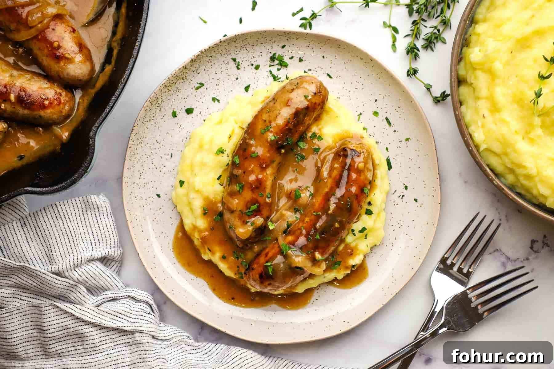 Classic British Bangers and Mash with Rich Onion Gravy 3 a plate of bangers and mash with gravy on top