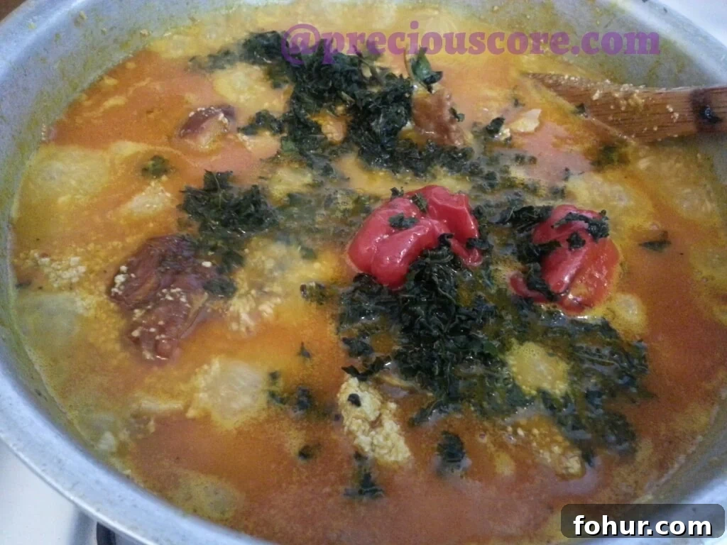 Ogbono and Egusi Soup Recipe: Classic Nigerian Soup 11 Adding greens to soup