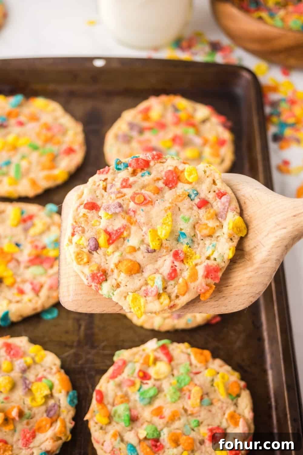 Fruity Pebbles Cookies Recipe for Crispy Colorful Treats 4 a spatula lifts a cookie made with Fruity Pebbles off of the baking sheet.
