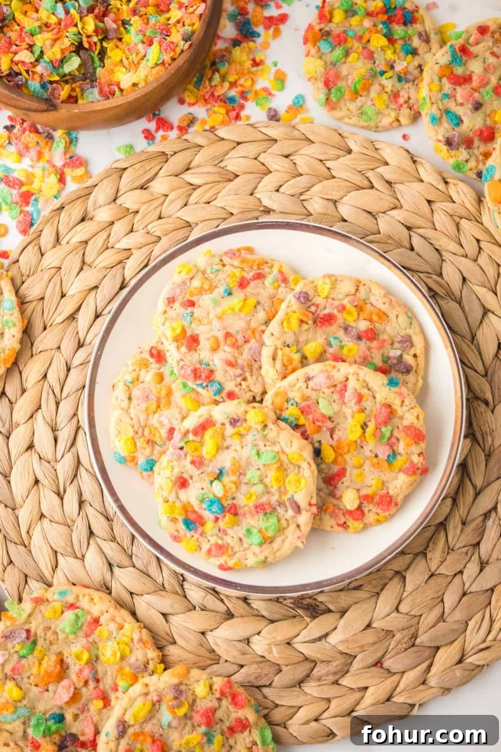 Fruity Pebbles Cookies Recipe for Crispy Colorful Treats 9 overhead view of a plate of soft and chewy Fruity Pebbles cookies on a straw placemat.
