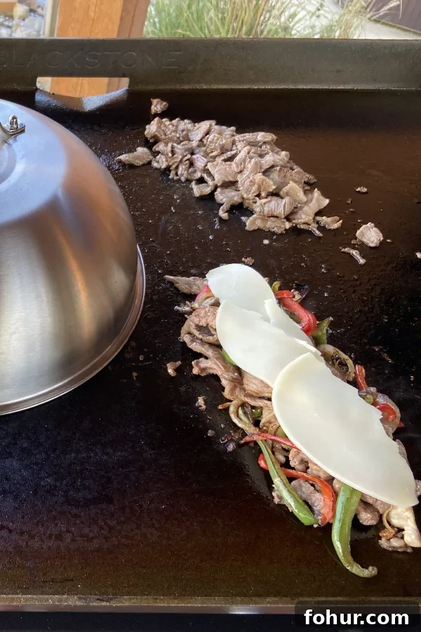 Philly Cheesesteak Recipe: Classic Homemade Sandwich 4 provolone cheese melting on meat and vegetables