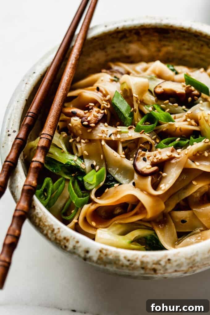 ho fan noodles in a white speckled ceramic bowl