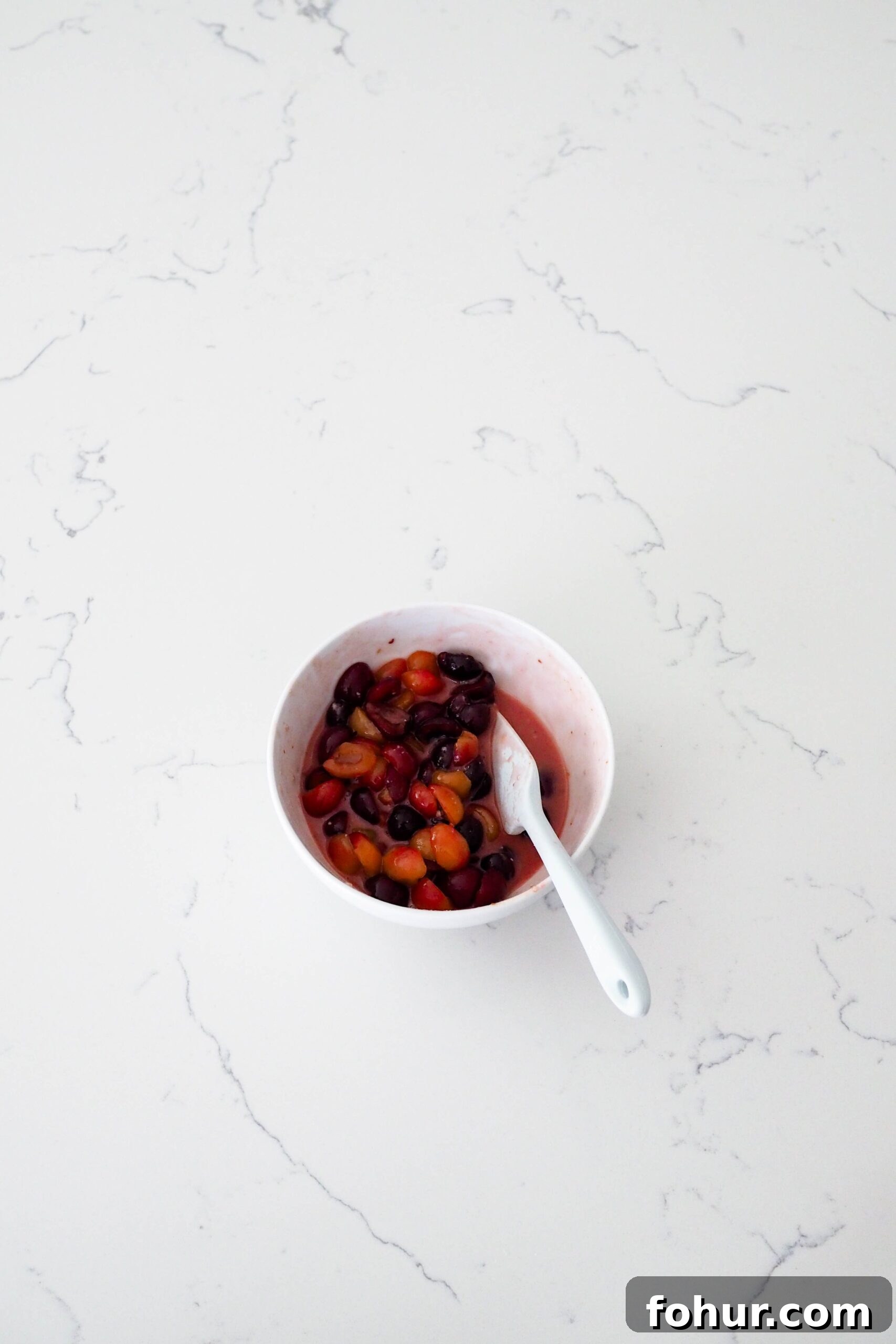 Cherry Crumble Bars with Buttery Oat Crust 5 Dark cherries in a white bowl with a dark pink liquid.