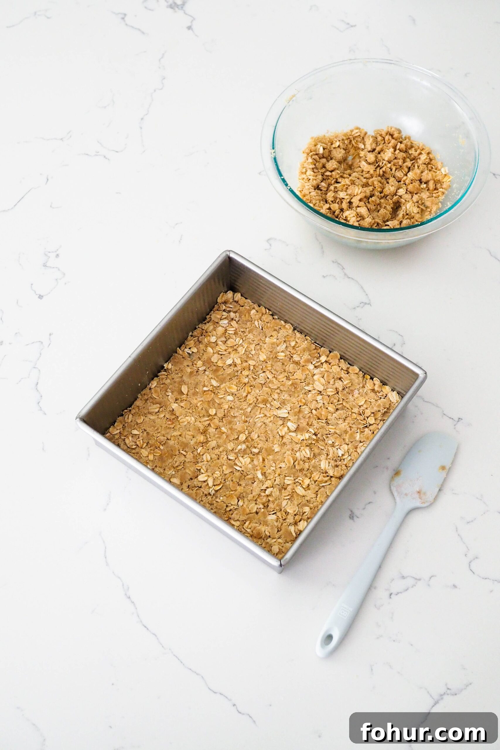 Cherry Crumble Bars with Buttery Oat Crust 8 A square pan with oat crumble pressed into the bottom.