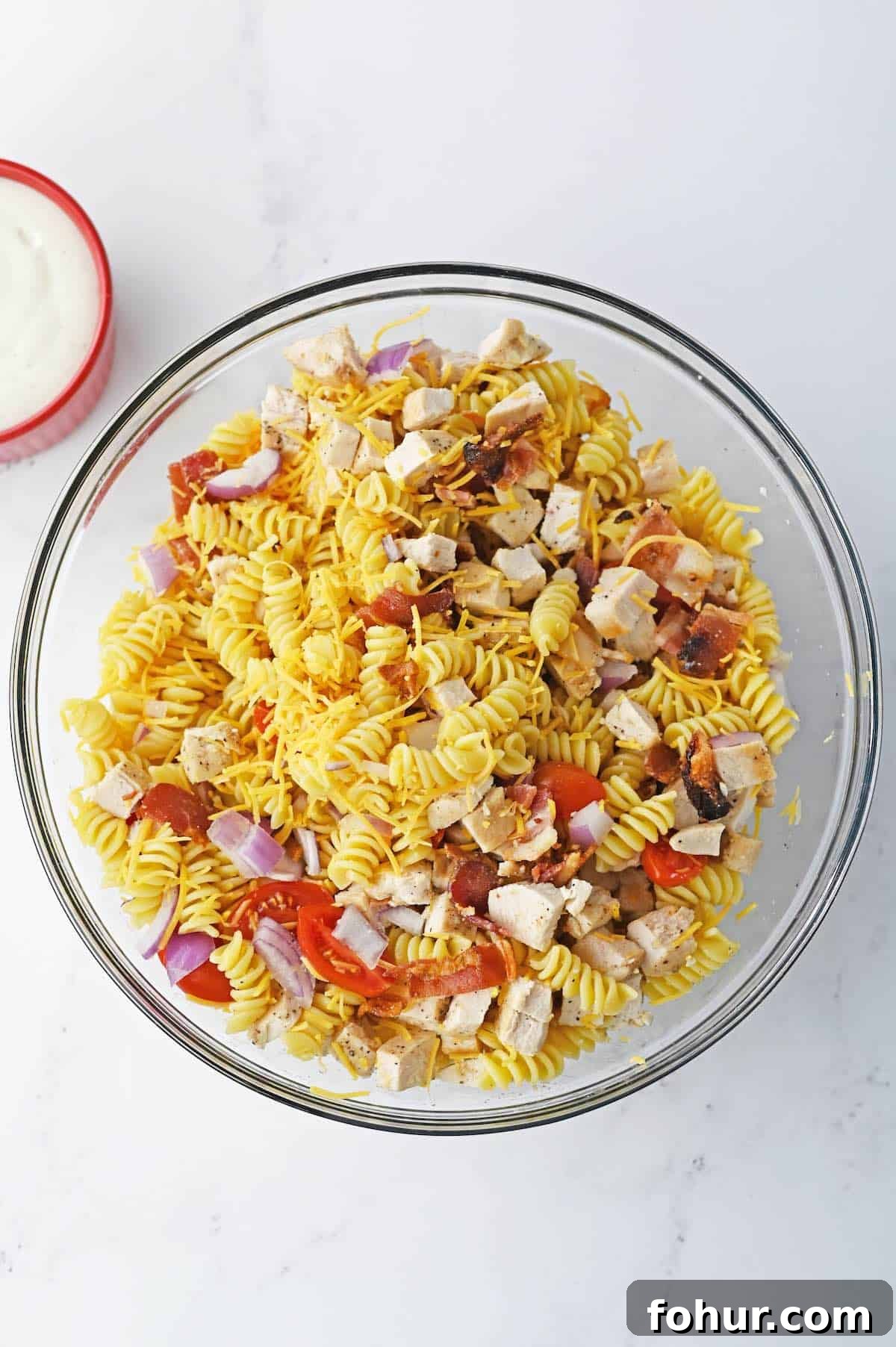 Rotini pasta tossed with tomatoes, bacon, red onion.