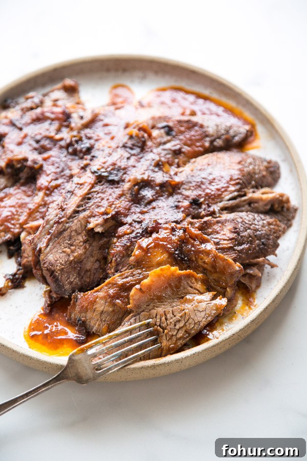 Passover Brisket Recipe for Any Jewish Holiday Dinner 9 sliced jewish brisket on a platter with fork