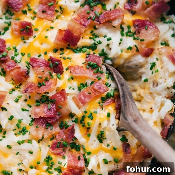 A warm, hearty scoop of crockpot hashbrown casserole, steaming and ready to be served.