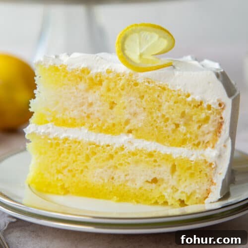 slice of lemon poke cake with cool whip frosting.