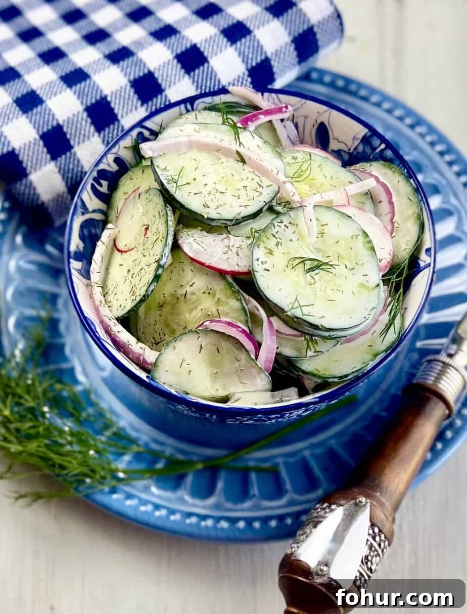 Creamy Cucumber Salad with Greek Yogurt and Dill 2 Creamy cucumber salad in a blue and white bowl.