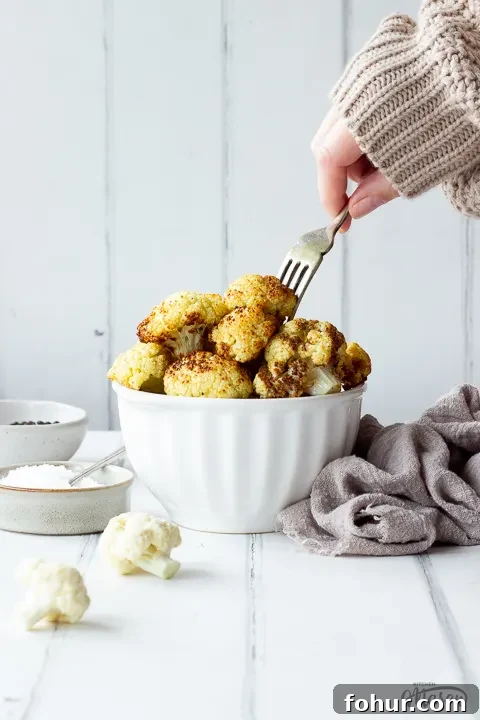 How to Cook Cauliflower: Roast, Steam, Saute and More 5 Someone forking a floret of roast cauliflower from a bowl