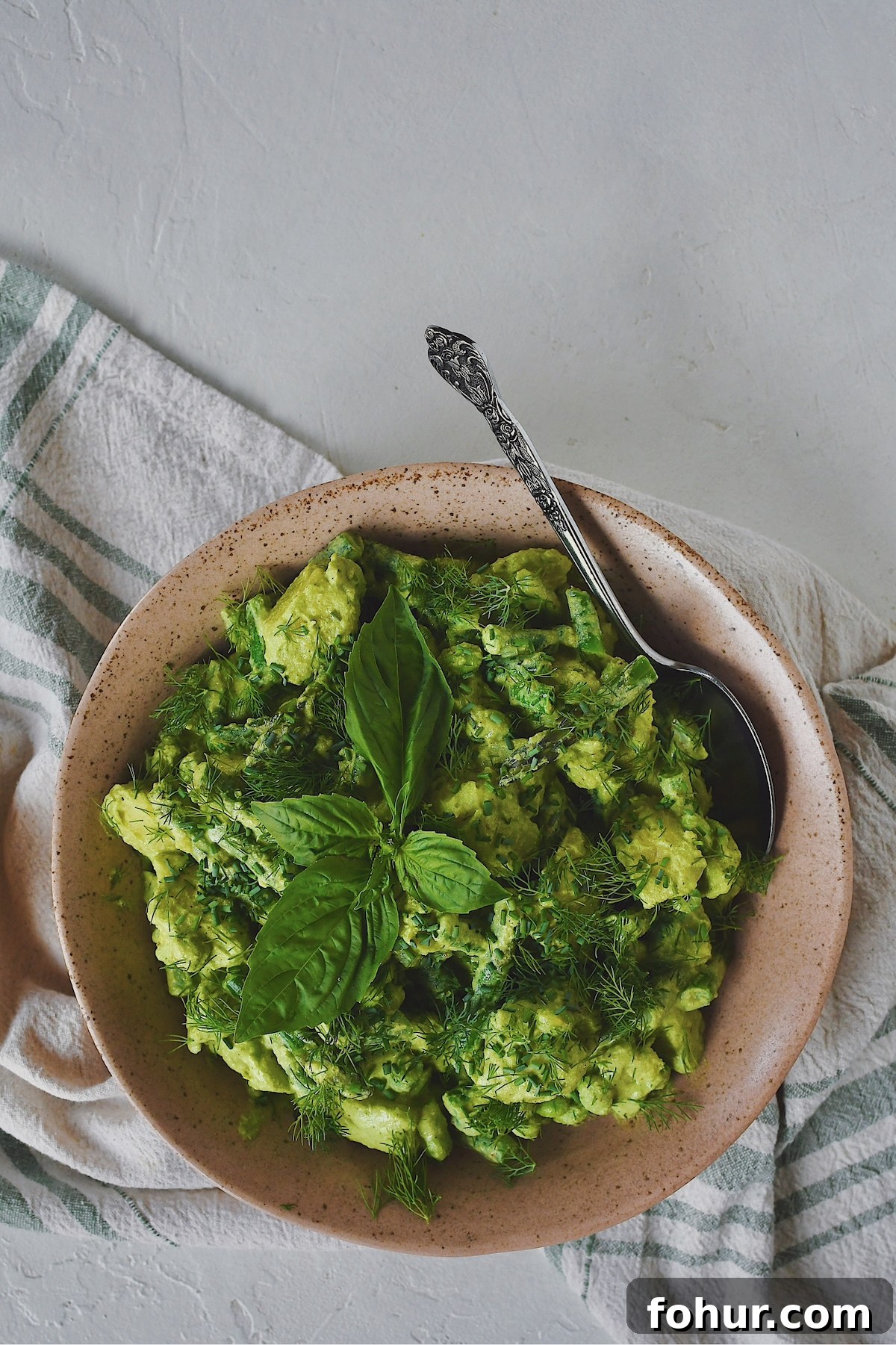 Creamy Green Goddess Potato Salad Recipe 2 Green Goddess Potato Salad in a serving bowl with a large spoon ready to be dished up.