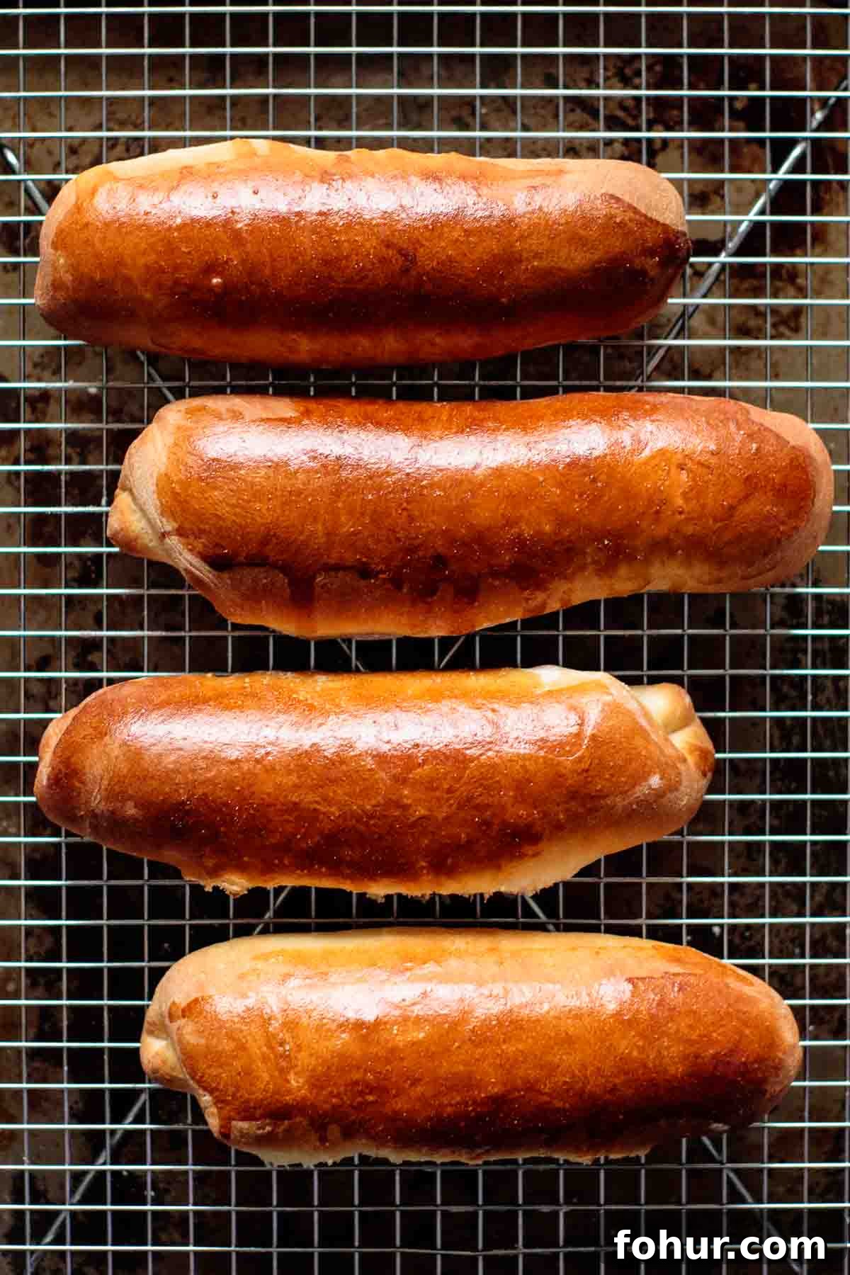 How to Make Brioche Hot Dog Buns from Scratch 6 Buns cooling on a cooling rack.