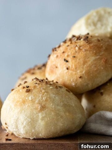 Baked focaccia rolls on top of wooden board.