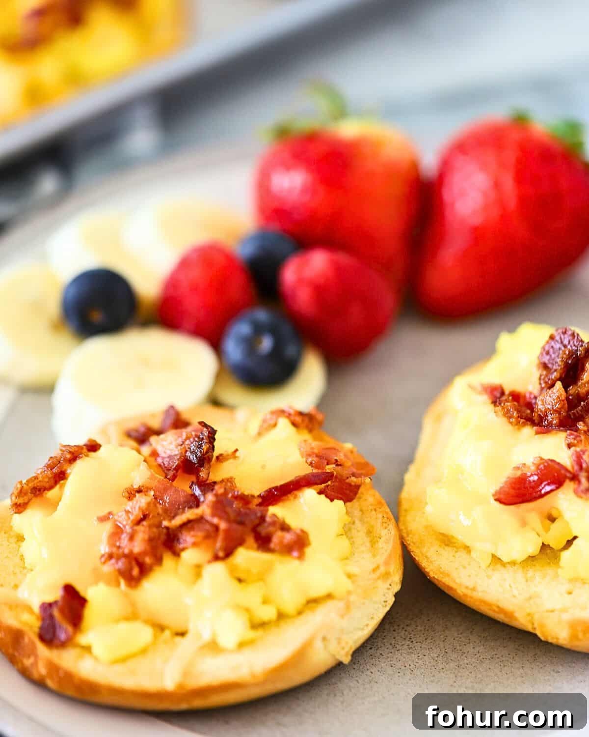 Breakfast Bagel Recipe with Egg, Bacon & Melted Cheese 2 A bagel topped with egg and cheese on a plate.