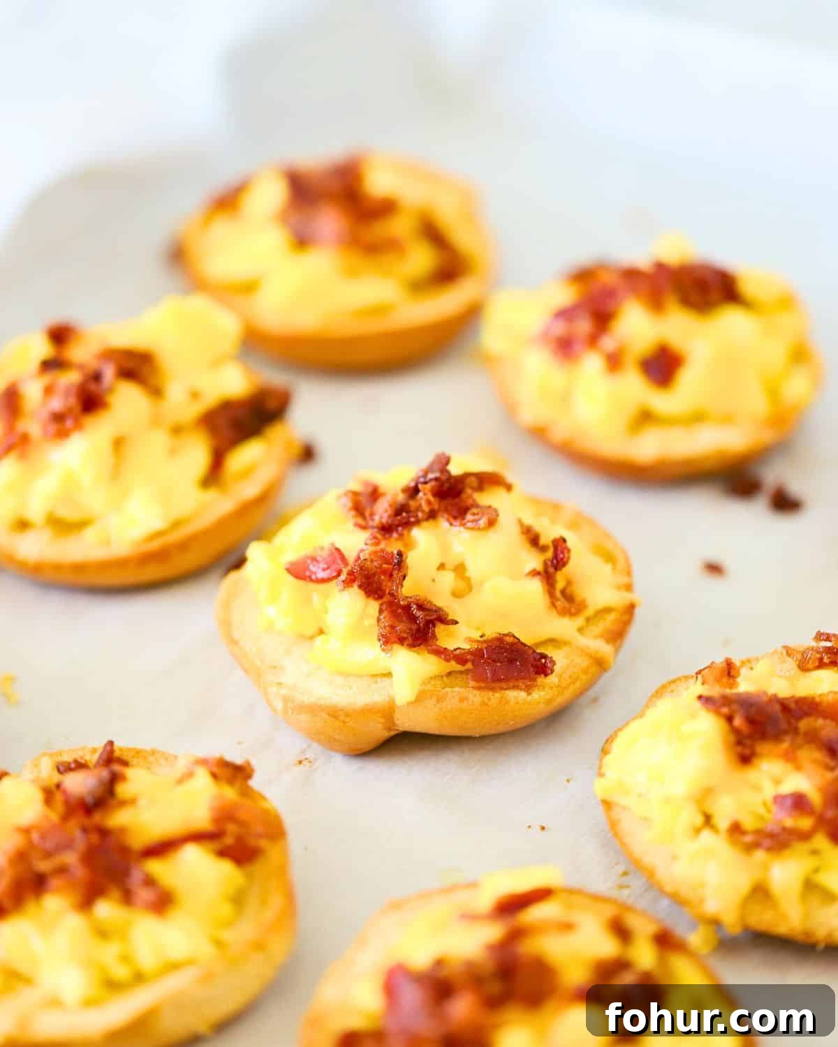 Breakfast Bagel Recipe with Egg, Bacon & Melted Cheese 7 Breakfast bagels on a plate.
