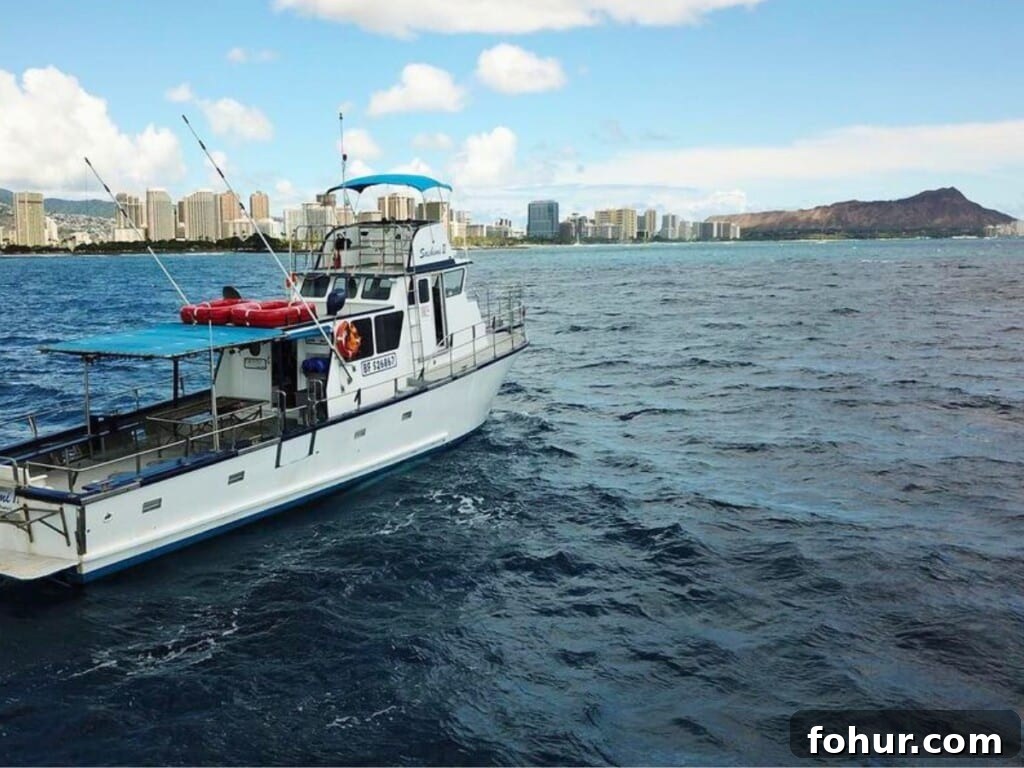Bottom Fishing Adventure boat tour in the ocean with Diamond Head in the background.