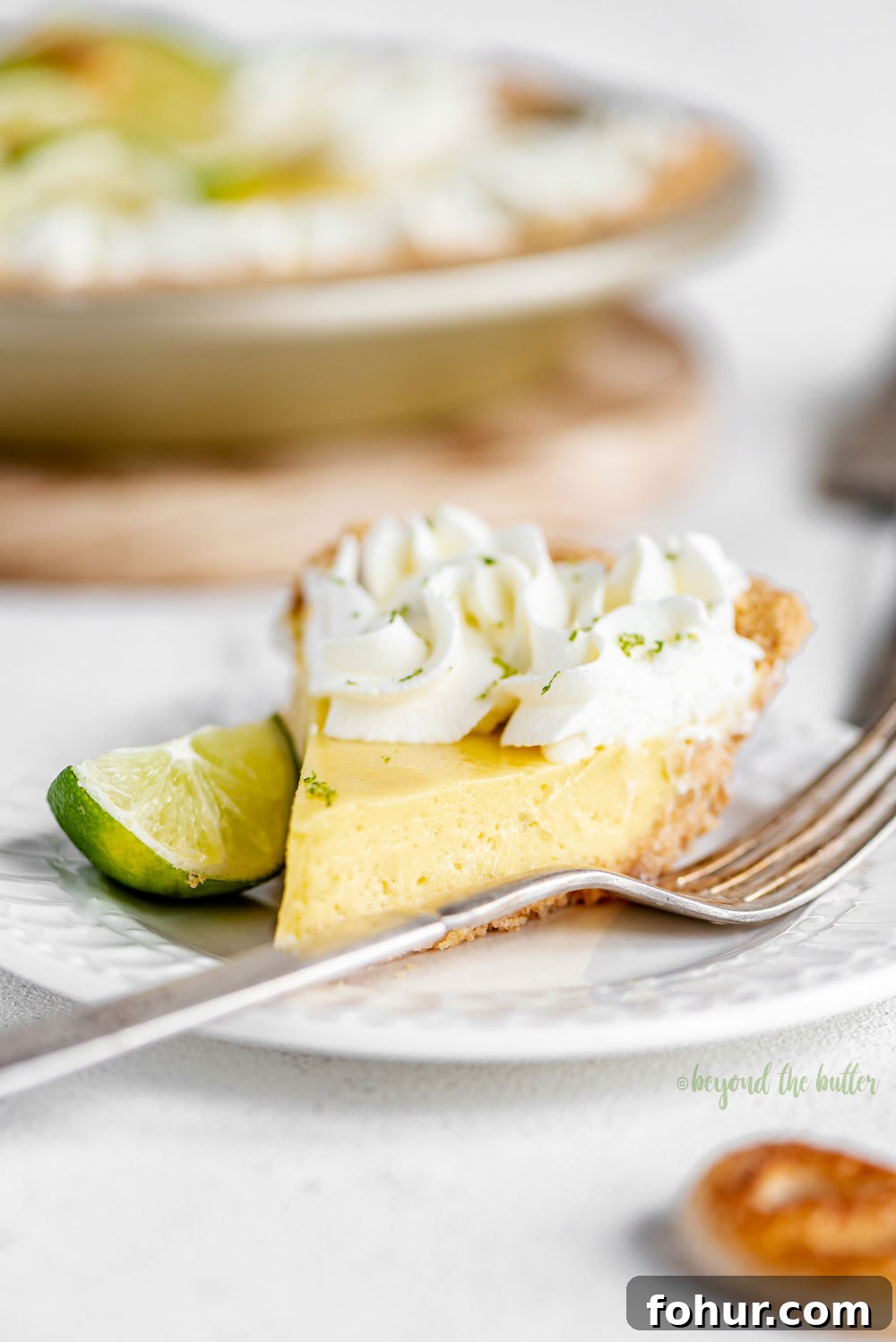 Classic Key Lime Pie Recipe with Graham Cracker Crust 3 Easy Key Lime Pie decorated with homemade whipped cream, puff pastry twists, and sliced limes | Image and Copyright Policy: © Beyond the Butter, LLC