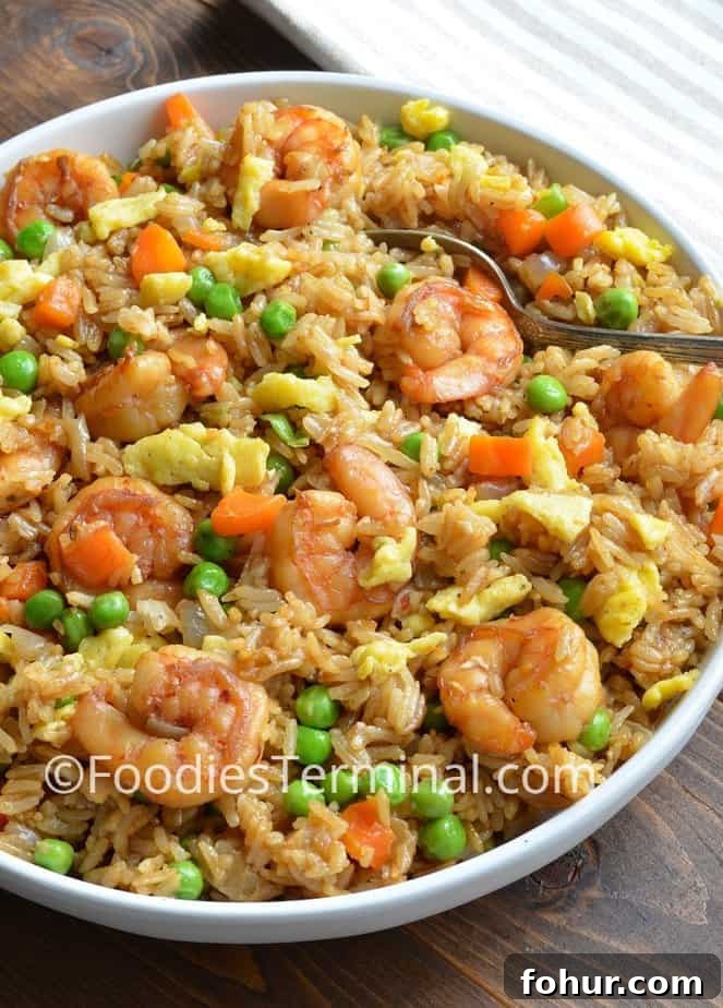 authentic shrimp fried rice recipe in a white plate with a spoon