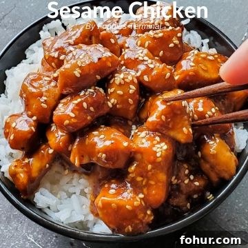 Sesame Chicken on rice in a black bowl