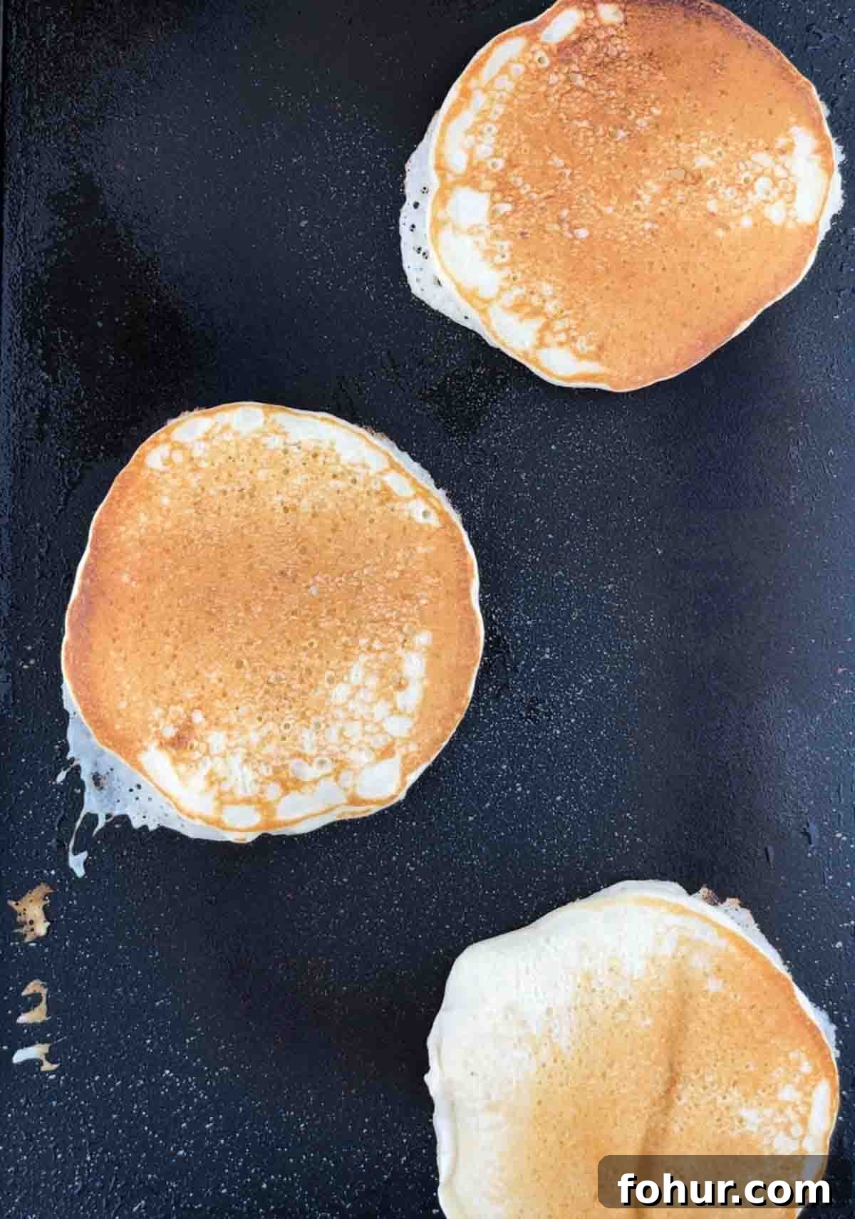 How to Make Fluffy Banana Pancakes 10 The pancakes flipped over on an electric griddle.
