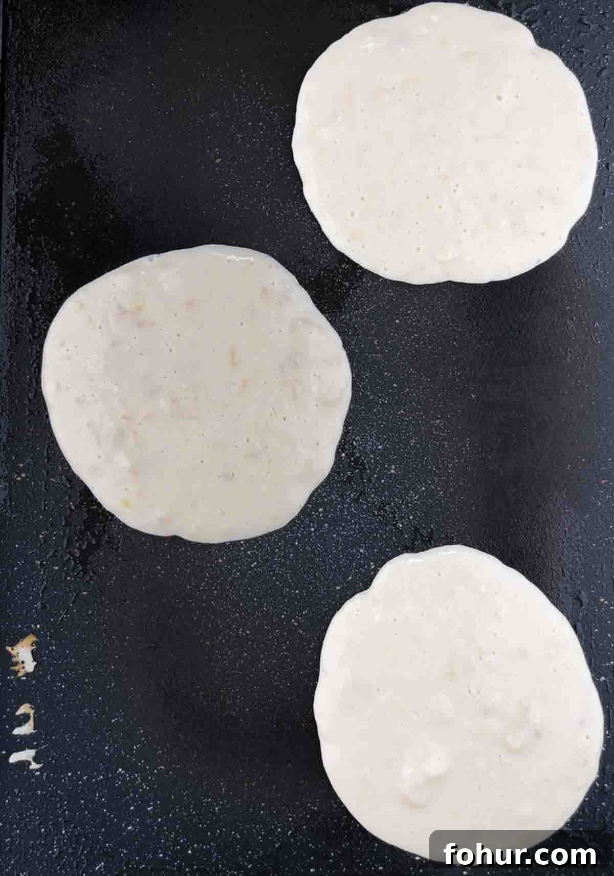 How to Make Fluffy Banana Pancakes 9 The pancake batter poured onto an electric griddle.