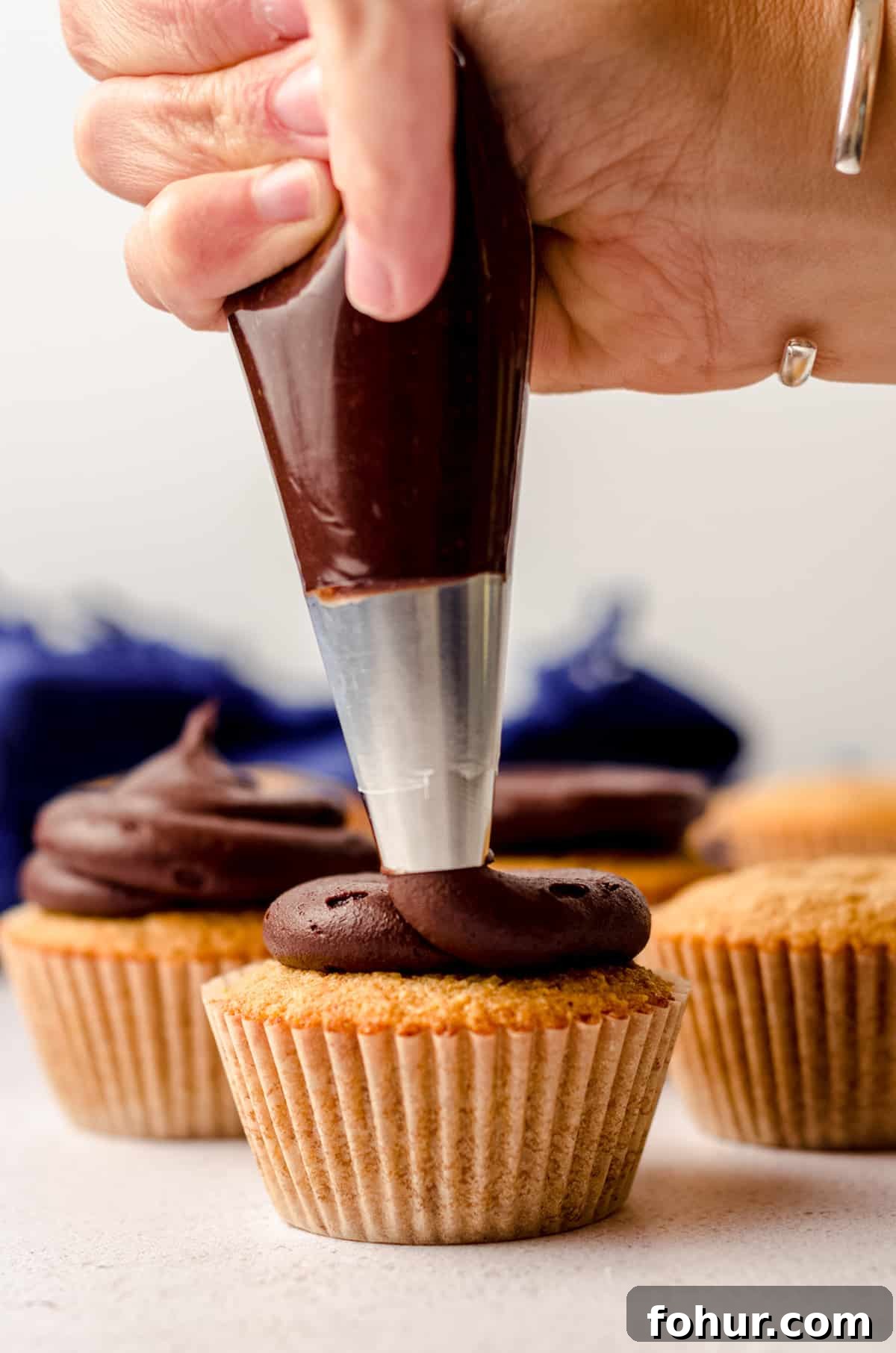 Decadent S'mores Cupcakes with Toasted Marshmallow Frosting 6 piping chocolate buttercream onto a s'mores cupcake
