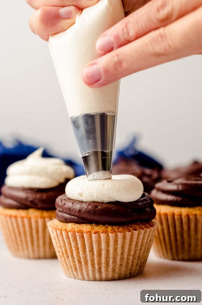 Decadent S'mores Cupcakes with Toasted Marshmallow Frosting 8 piping marshmallow buttercream onto a s'mores cupcake
