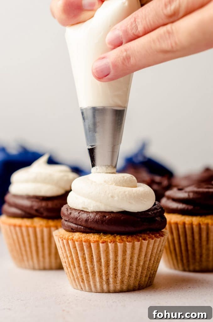 Decadent S'mores Cupcakes with Toasted Marshmallow Frosting 9 piping marshmallow buttercream onto a s'mores cupcake