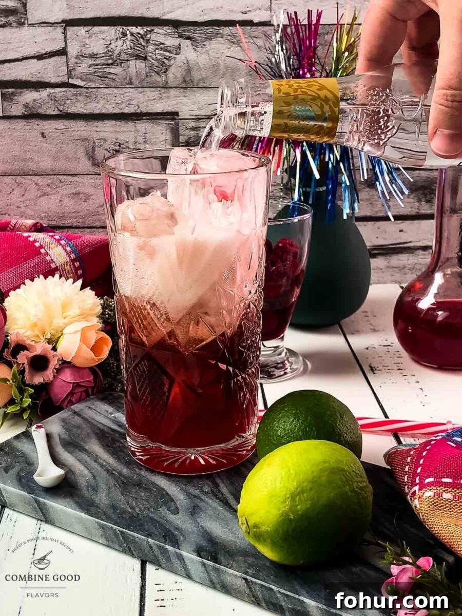 Raspberry Gin and Tonic Cocktail Recipe 7 Topping the drink with tonic water.