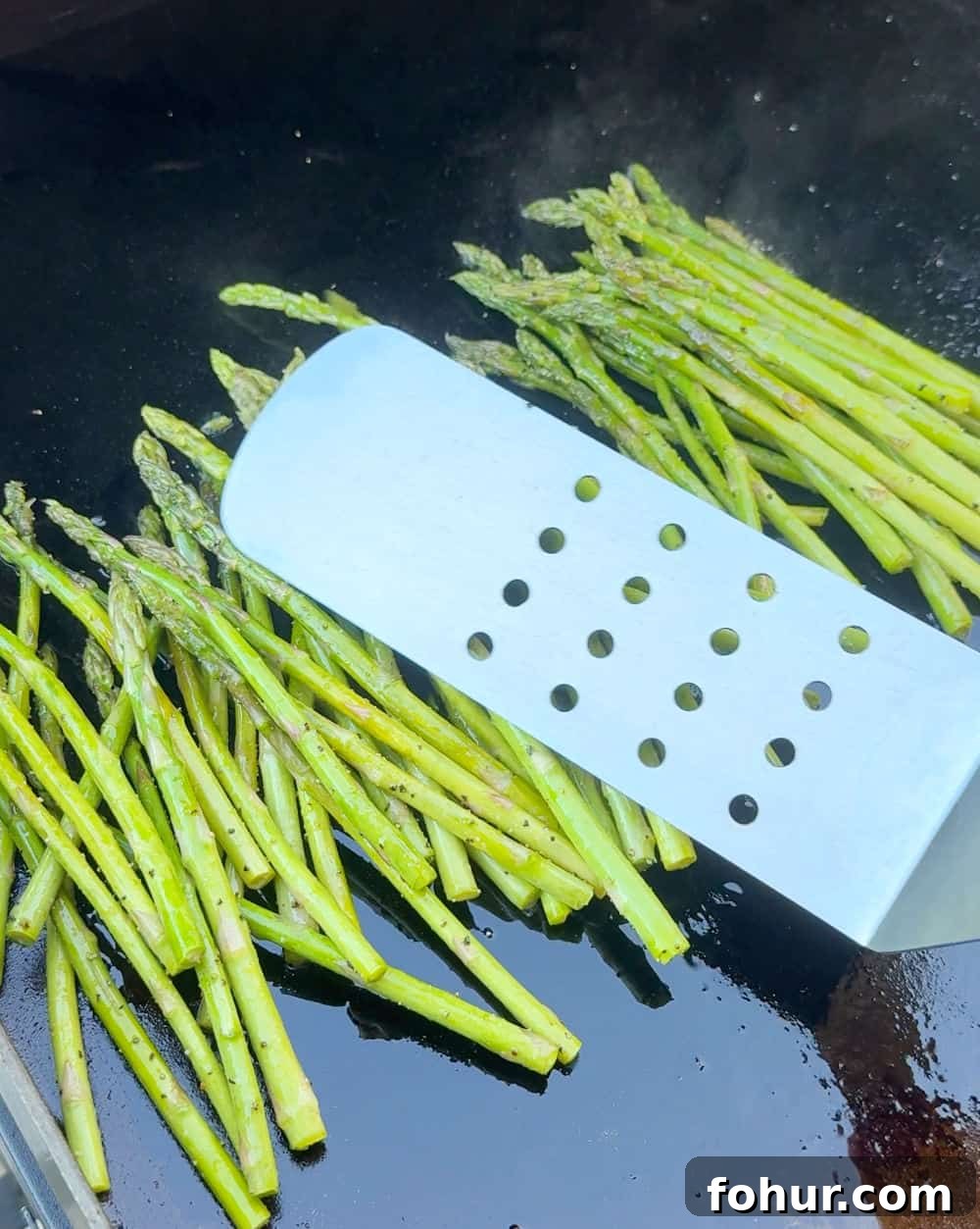Blackstone Griddle Asparagus Recipe: Quick Grilled Asparagus 6 stir asparagus with grilling spatula.