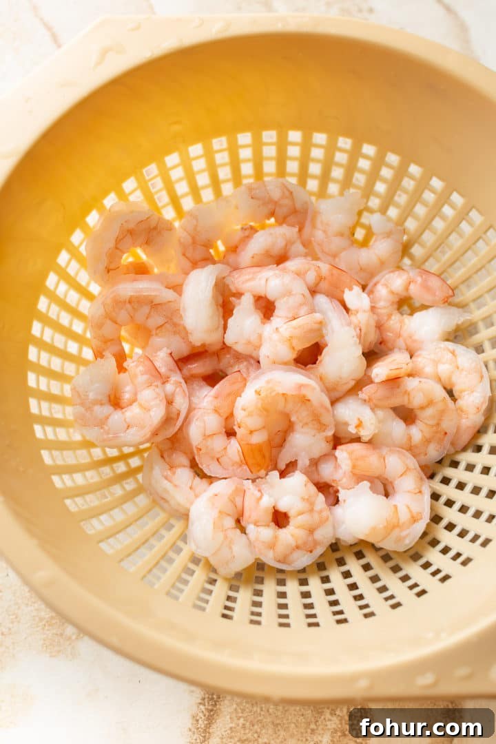 Zesty Shrimp Salad Recipe with Avocado and Lime Dressing 2 cooked shrimp in a colander