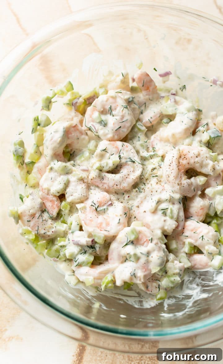 Zesty Shrimp Salad Recipe with Avocado and Lime Dressing 4 close-up of cold shrimp salad in a glass prep bowl
