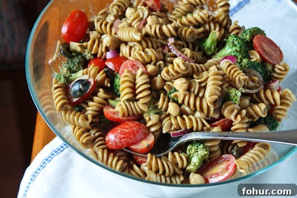 Pasta Salad with Balsamic Basil Vinaigrette pasta salad with cherry tomatoes, olives, red onions, and broccoli in a bowl